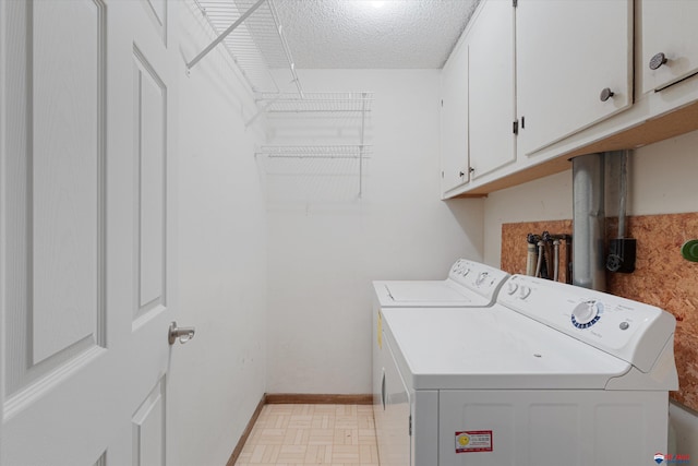 laundry area featuring cabinet space, independent washer and dryer, baseboards, and a textured ceiling