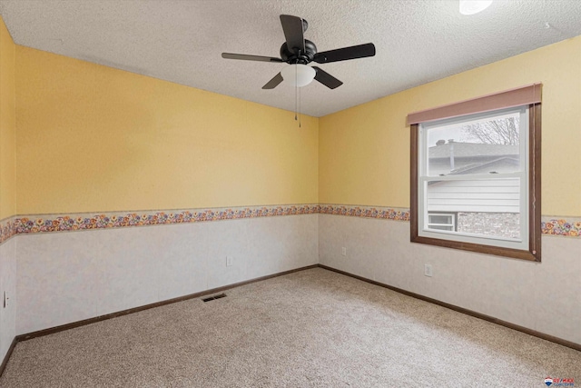 unfurnished room with carpet floors, a ceiling fan, a textured ceiling, and baseboards