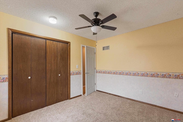 unfurnished bedroom with carpet flooring, baseboards, visible vents, and a closet