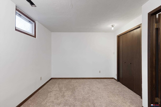 interior space featuring baseboards, a textured ceiling, carpet, and a closet