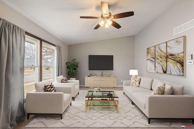 living room featuring ceiling fan, visible vents, baseboards, lofted ceiling, and light carpet
