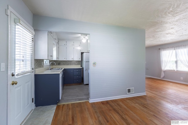 kitchen featuring freestanding refrigerator, visible vents, light wood-type flooring, and light countertops