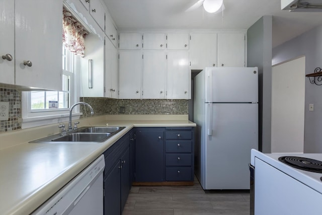 kitchen with a sink, white cabinetry, backsplash, and white appliances