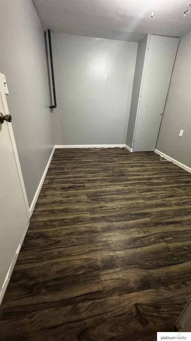 finished below grade area with baseboards and dark wood finished floors