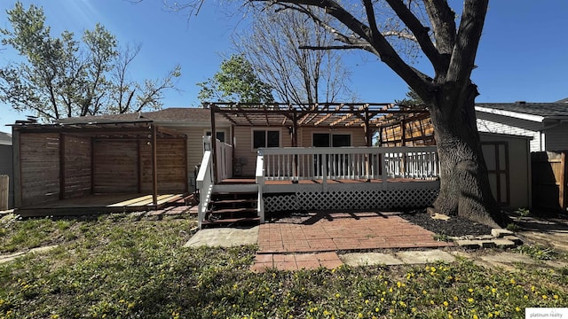 rear view of house with a storage shed, a wooden deck, an outbuilding, fence, and a pergola