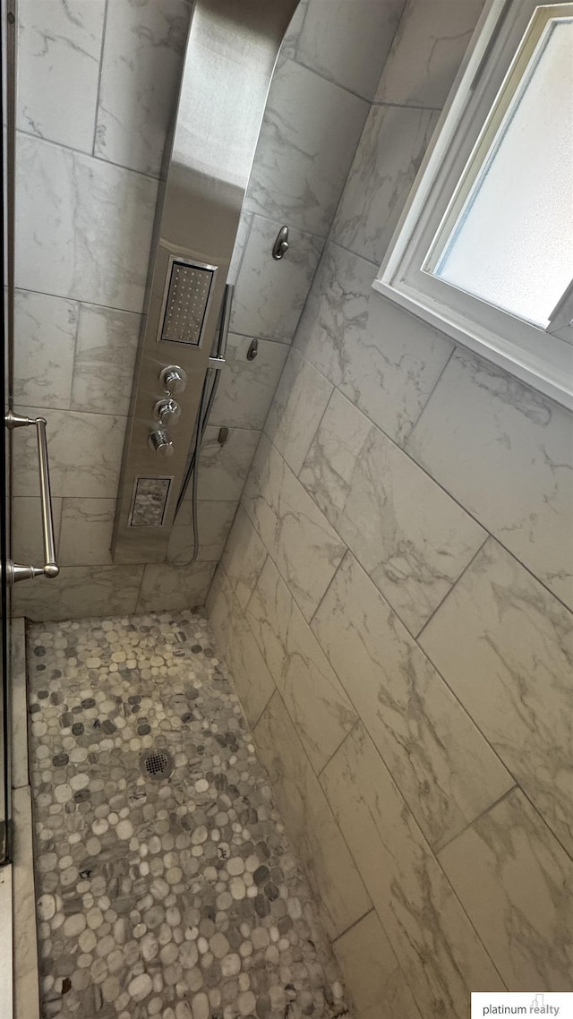 full bath featuring tiled shower