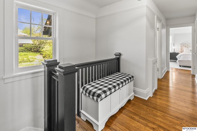 bedroom with baseboards, wood finished floors, and multiple windows