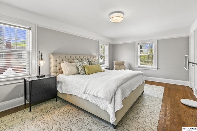 bedroom with baseboards and wood finished floors