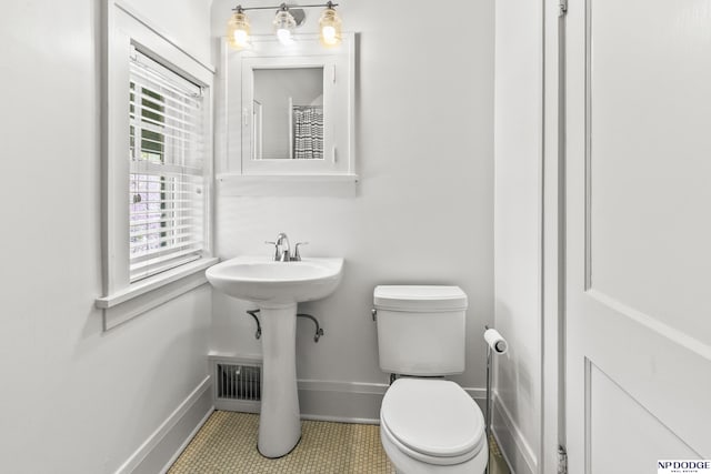 bathroom featuring visible vents, tile patterned flooring, a sink, baseboards, and toilet