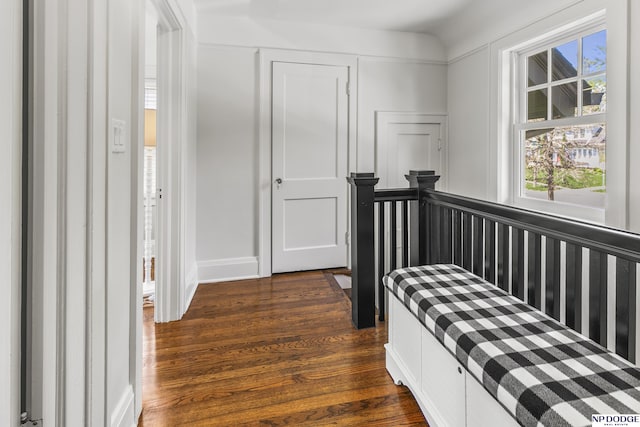 bedroom featuring baseboards, dark wood finished floors, multiple windows, and a closet