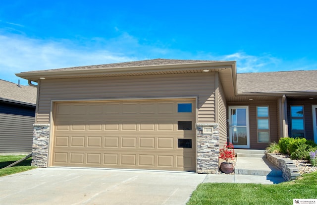 prairie-style home featuring an attached garage, driveway, and stone siding