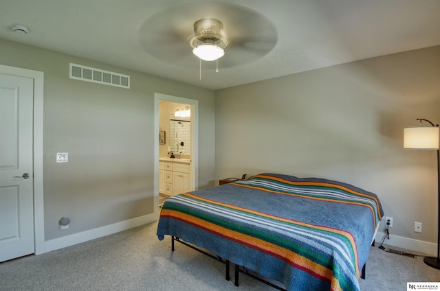 bedroom with a ceiling fan, visible vents, baseboards, carpet floors, and ensuite bath