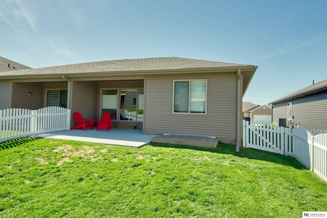 rear view of house featuring a yard, a fenced backyard, and a patio area