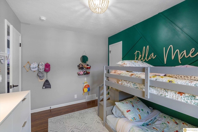 bedroom with baseboards, dark wood finished floors, and visible vents