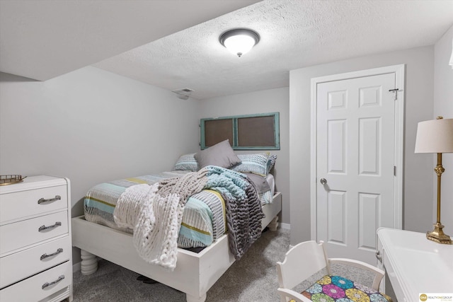 bedroom with carpet floors, a textured ceiling, and visible vents