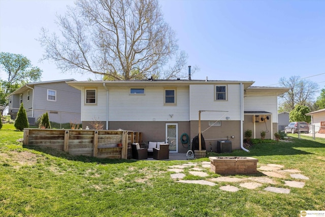 back of property featuring a yard, central AC, fence, and a fire pit