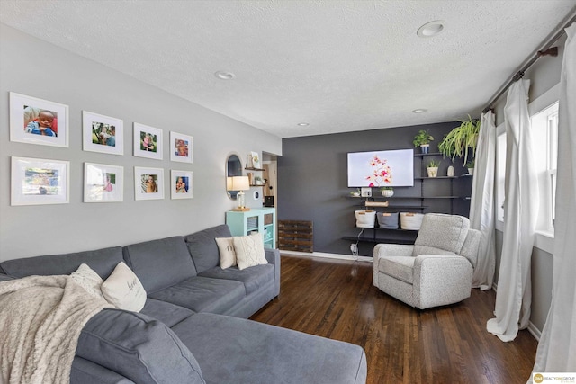 living room featuring baseboards, recessed lighting, a textured ceiling, and wood finished floors