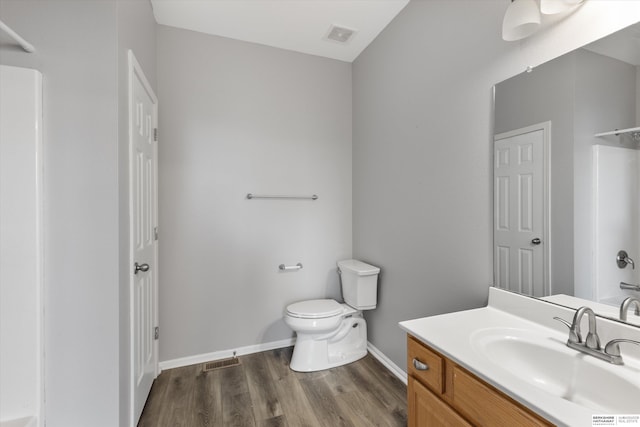 full bath featuring visible vents, wood finished floors, vanity, baseboards, and toilet