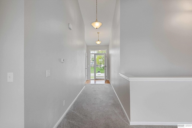 hallway with carpet floors and baseboards