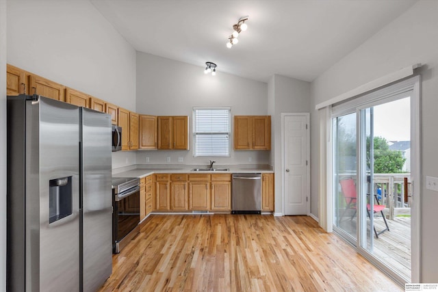 kitchen featuring high vaulted ceiling, light wood-type flooring, light countertops, a sink, and appliances with stainless steel finishes
