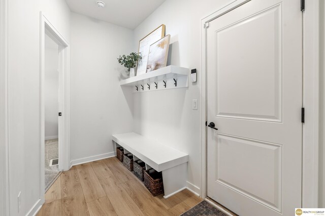 mudroom featuring light wood-style floors, baseboards, and visible vents