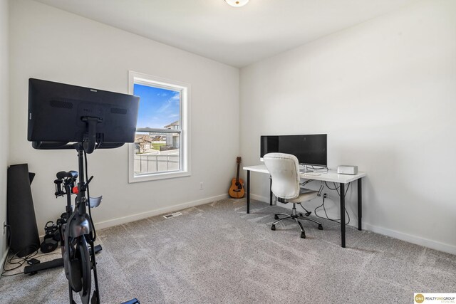 office space with carpet floors, baseboards, and visible vents