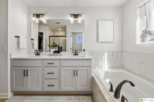 full bath featuring visible vents, a shower stall, a sink, and a garden tub