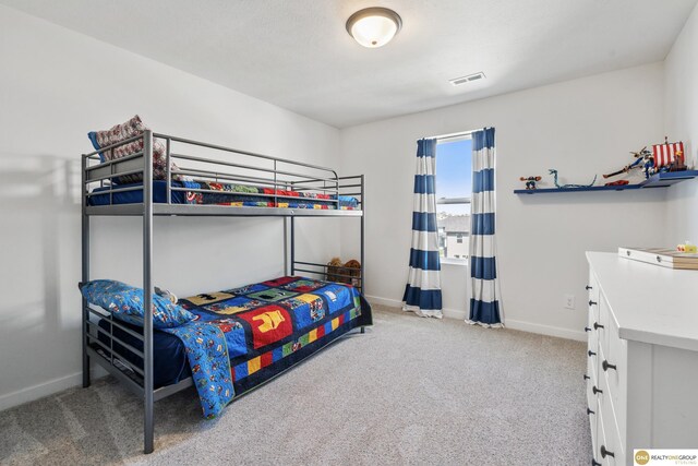 carpeted bedroom featuring baseboards and visible vents
