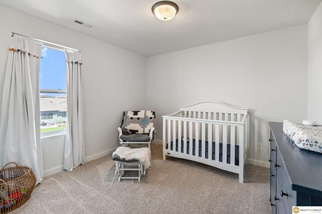 bedroom with carpet floors, visible vents, and multiple windows