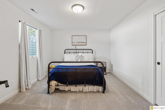 carpeted bedroom with baseboards and visible vents