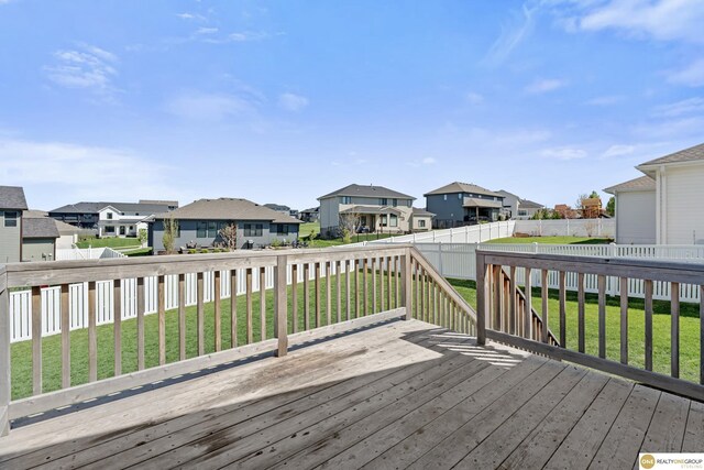 wooden terrace with a lawn, a fenced backyard, and a residential view