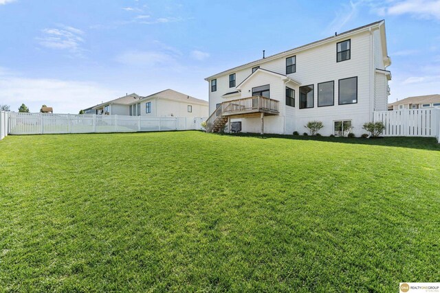rear view of house with a lawn, a deck, stairs, and a fenced backyard