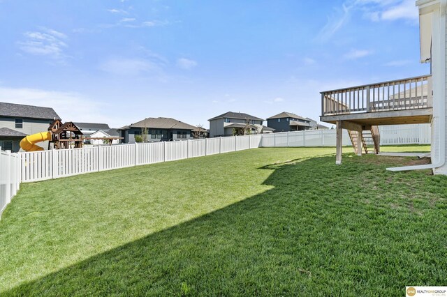 view of yard featuring stairs, a fenced backyard, a residential view, and a deck