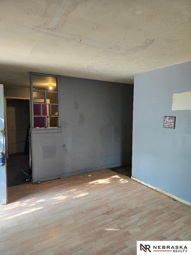 empty room featuring wood finished floors and a textured ceiling