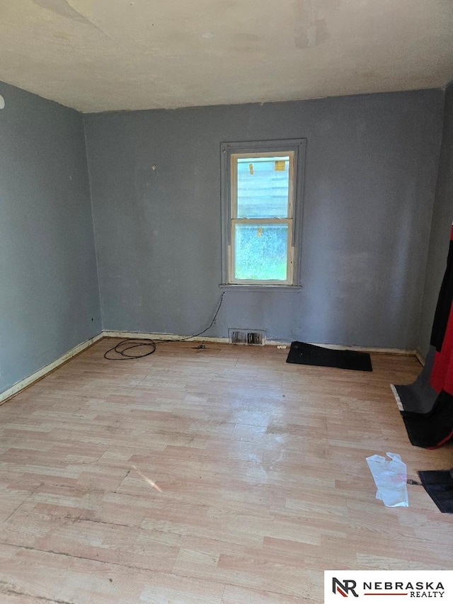 spare room featuring wood finished floors and baseboards