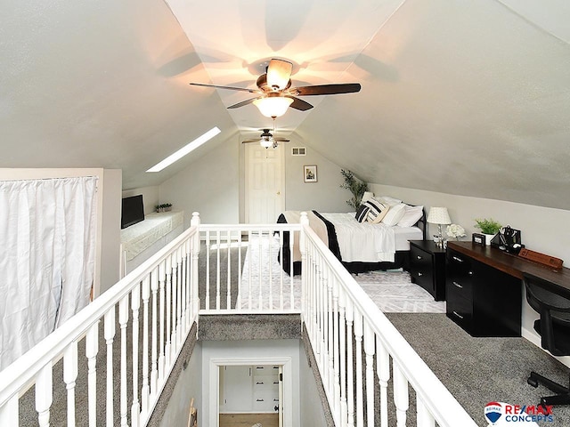 interior space featuring ceiling fan, visible vents, and vaulted ceiling with skylight