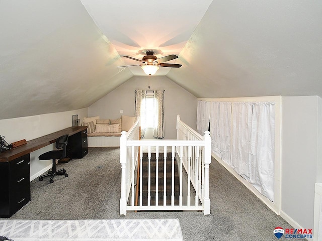 carpeted office with baseboards, ceiling fan, and vaulted ceiling