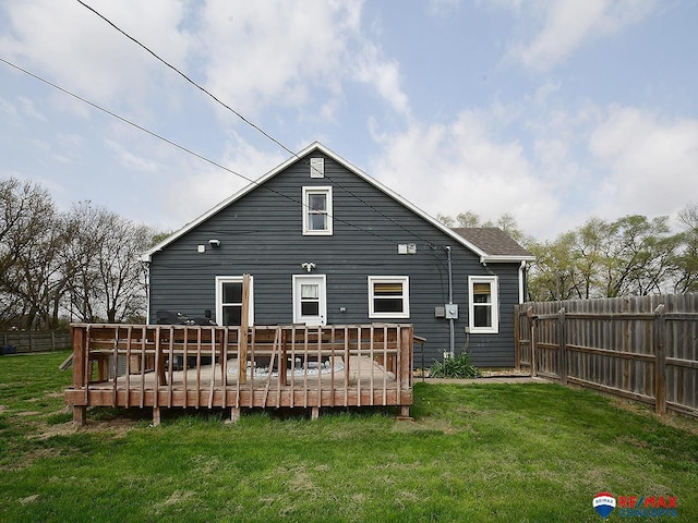 rear view of house featuring a yard, a deck, and fence