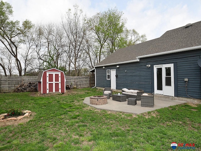 view of yard with an outdoor structure, an outdoor fire pit, a storage shed, a fenced backyard, and a patio