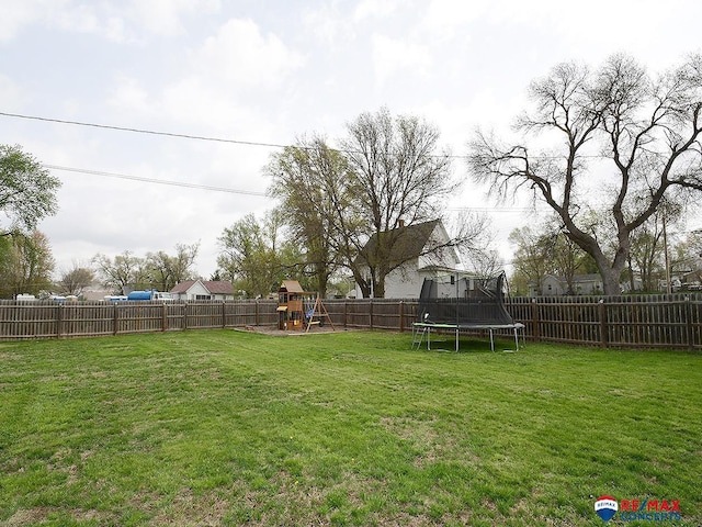 view of yard featuring a playground, a trampoline, and a fenced backyard