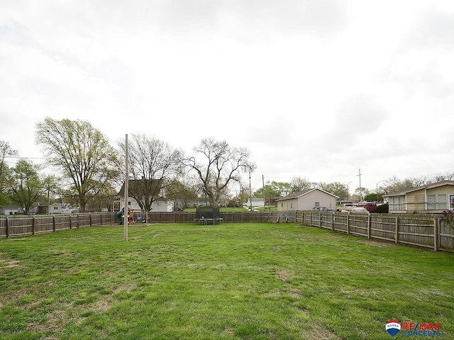 view of yard featuring a fenced backyard, a trampoline, and a playground