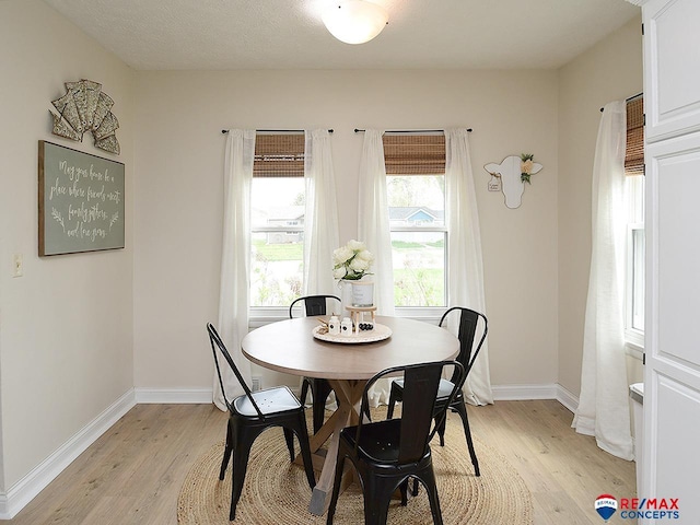dining room featuring baseboards and light wood-type flooring