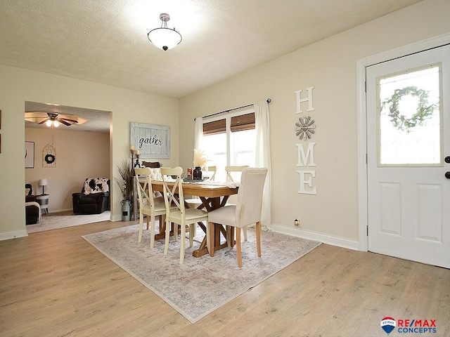 dining space with baseboards, ceiling fan, and light wood-style floors
