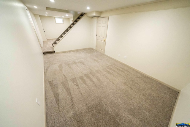 finished basement with stairs, recessed lighting, and light colored carpet
