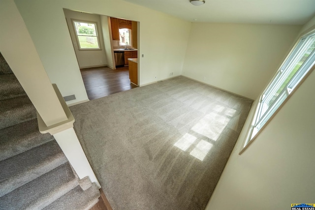 spare room featuring visible vents, stairs, baseboards, a sink, and carpet