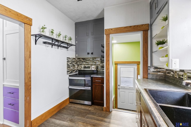 kitchen featuring open shelves, dark wood-style floors, double oven range, and a sink