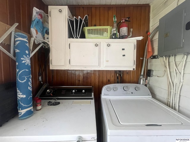 washroom featuring wooden walls, cabinet space, and washer / clothes dryer