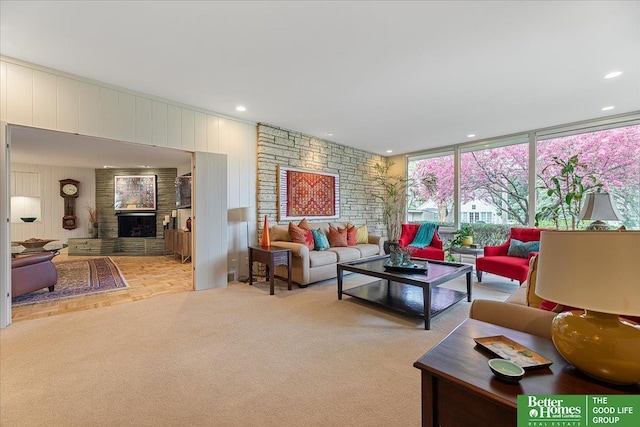 carpeted living room featuring recessed lighting, wood walls, a brick fireplace, and expansive windows