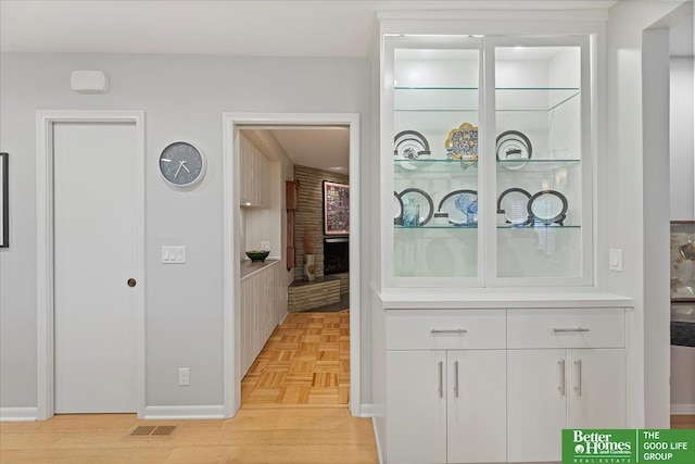 corridor featuring visible vents and baseboards