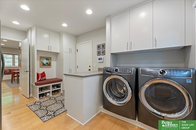 laundry area featuring washing machine and clothes dryer, cabinet space, recessed lighting, baseboards, and light wood-type flooring